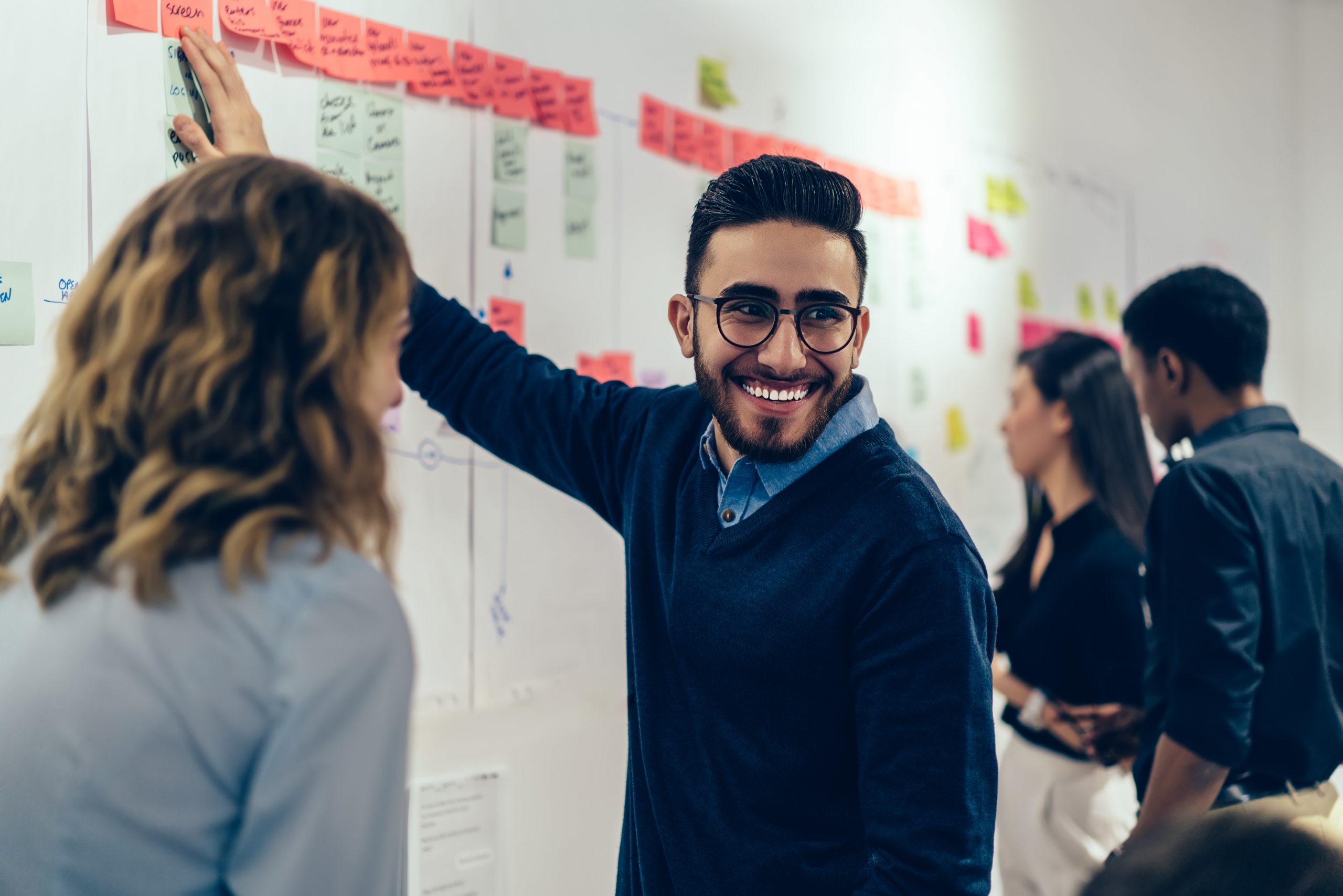 A professional team collaborating at a whiteboard during a listening and communication workshop